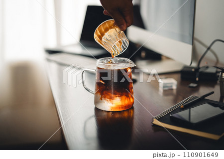Iced coffee in a glass mug on the work desk Iced coffee in a glass mug on the work desk 110901649