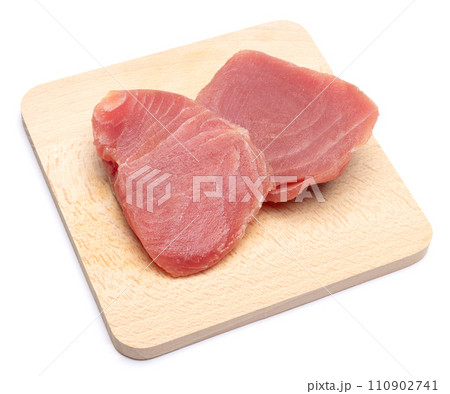 Fresh tuna Fish steak on a wooden cutting serving board isolated on a white background Fresh tuna Fish steak on a wooden cutting serving board isolated on a white background 110902741