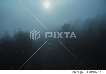 road with cars in city on a foggy morning in autumn in fog mist 110902849