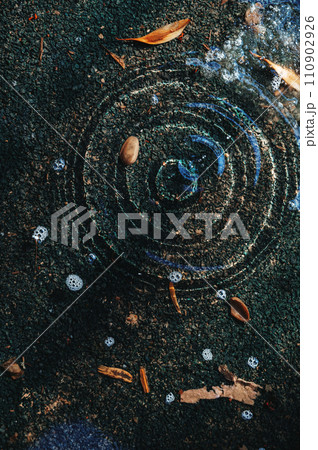puddle on asphalt with drops of spring raindrops and circles on water puddle on asphalt with drops of spring raindrops and circles on water 110902926