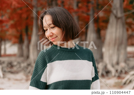 Smiling woman in autumnal park. Stylish woman with happy emotions Smiling woman in autumnal park. Stylish woman with happy emotions 110904447
