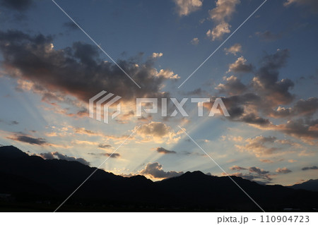 山に沈む夕陽と光線 110904723