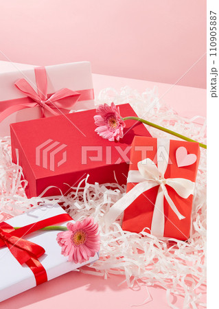 A red podium with empty space placed on a pile of kraft paper with beautiful gift boxes and pink flowers. Concept scene stage showcase for new product, promotion sale, cosmetic presentation A red podium with empty space placed on a pile of kraft paper with beautiful gift boxes and pink flowers. Concept scene stage showcase for new product, promotion sale, cosmetic presentation 110905887