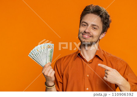 Rich happy man winner waving money dollar cash like a fan, big income wealth success business 110906392