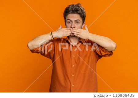 Frightened young man closing mouth with hands refusing to tell terrible secret unbelievable truth 110906435
