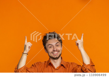 Young man showing promotion, pointing overhead up on blank space place for your advertisement logo Young man showing promotion, pointing overhead up on blank space place for your advertisement logo 110906499
