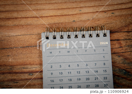DECEMBER 2024. Green cardboard calendar on a wooden texture background 110906924