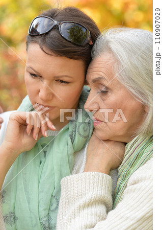 Sad woman with her mother in the autumn park Sad woman with her mother in the autumn park 110907029