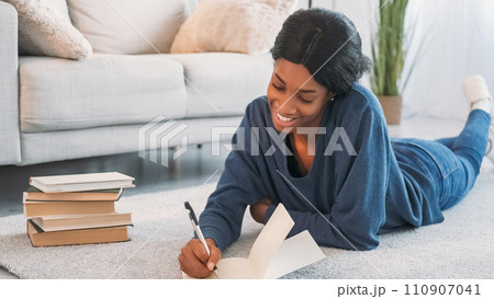 Diary weekend. Writing inspiration. Thoughtful happy woman taking notes of ideas in journal enjoying home leisure on floor in cozy living room. Diary weekend. Writing inspiration. Thoughtful happy woman taking notes of ideas in journal enjoying home leisure on floor in cozy living room. 110907041