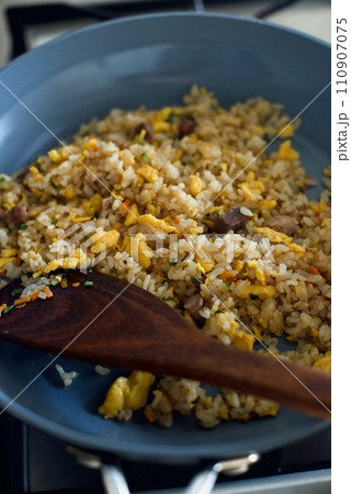 冷凍食品のチャーハンをフライパンで調理しているところ 110907075