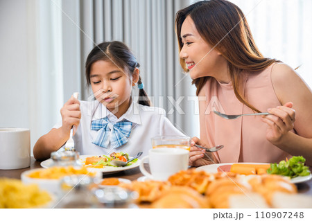 Family breakfast. Mom and little preschooler have fun smile eating meal together, Asian mother and child daughter having breakfast on food table, Healthy food at home in morning before go to school Family breakfast. Mom and little preschooler have fun smile eating meal together, Asian mother and child daughter having breakfast on food table, Healthy food at home in morning before go to school 110907248