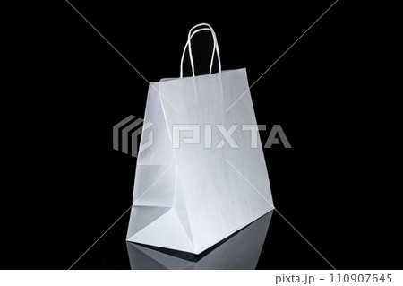 Recyclable craft paper bag for purchases, gifts and takeaway food mock up on black background. Environmentally friendly than single-use plastic bags 110907645
