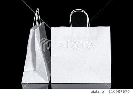 Recyclable craft paper bag for purchases, gifts and takeaway food mock up on black background. Environmentally friendly than single-use plastic bags Recyclable craft paper bag for purchases, gifts and takeaway food mock up on black background. Environmentally friendly than single-use plastic bags 110907676