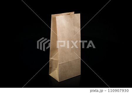 Recyclable craft paper bag for purchases, gifts and takeaway food mock up on black background. Environmentally friendly than single-use plastic bags Recyclable craft paper bag for purchases, gifts and takeaway food mock up on black background. Environmentally friendly than single-use plastic bags 110907930