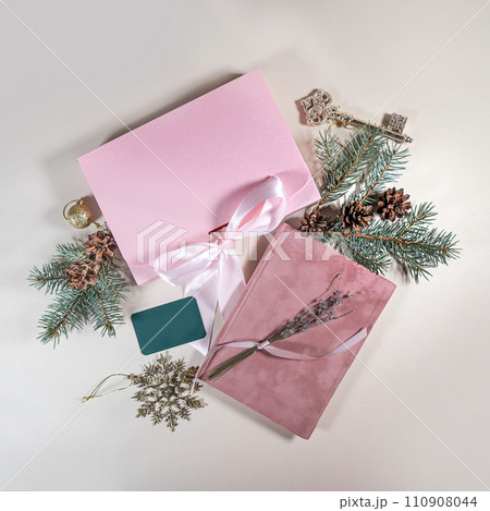 Beautiful gift pink cardboard box stars Christmas balls on beige background top view Flat lay. New Year presents Festive decorations 2024 celebration. Merry Christmas Happy Holidays card 110908044