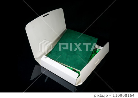 Best gift for men. Man gift concept. Green notebook with open white gift box on black background. Copy space text. Valentine's day, wedding, birthday and special occasion gift concept. Copy space. Best gift for men. Man gift concept. Green notebook with open white gift box on black background. Copy space text. Valentine's day, wedding, birthday and special occasion gift concept. Copy space. 110908164
