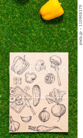 a paper bag lies on the green grass with fruits and vegetables around, moss, mock up 110908370