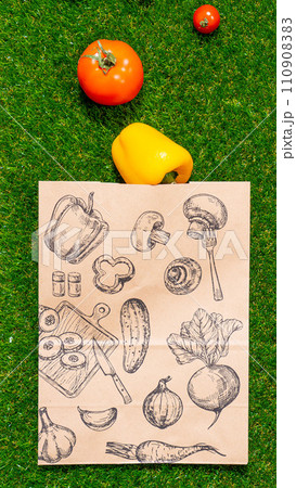 a paper bag lies on the green grass with fruits and vegetables around, moss, mock up 110908383