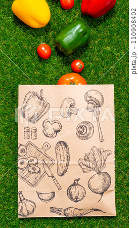 a paper bag lies on the green grass with fruits and vegetables around, moss, mock up 110908402