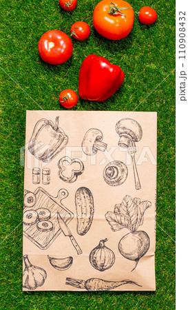 a paper bag lies on the green grass with fruits and vegetables around, moss, mock up 110908432