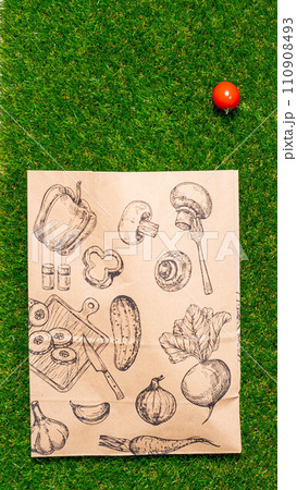 a paper bag lies on the green grass with fruits and vegetables around, moss, mock up 110908493