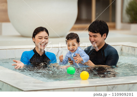 happy family. father and mother with small daughter in swimming pool. happy family. father and mother with small daughter in swimming pool. 110909201