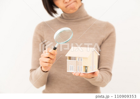 家の模型とルーペを持つミドル女性 110909353