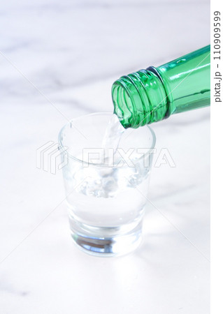 韓国の焼酎（ソジュ）をグラスに注ぐ 110909599