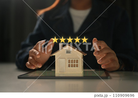 Businesswoman showing 5 stars rating with home model. Real estate appraisal concept and excellent service concept Businesswoman showing 5 stars rating with home model. Real estate appraisal concept and excellent service concept 110909696