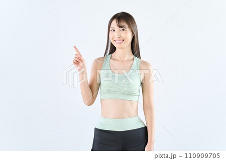 指差しをするスポーツウェアを着た女性 指差しをするスポーツウェアを着た女性 110909705