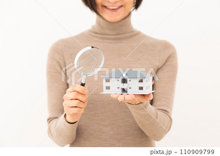 マンションの模型とルーペを持って笑うミドル女性 マンションの模型とルーペを持って笑うミドル女性 110909799