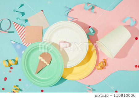 Colorful round plates, ribbons and cute decorations on a pastel blue background. Horizontal layout with birthday theme for commercial use. Close up. Colorful round plates, ribbons and cute decorations on a pastel blue background. Horizontal layout with birthday theme for commercial use. Close up. 110910006