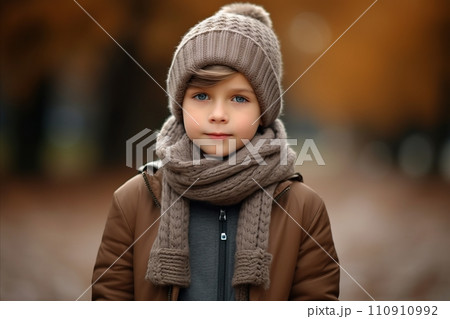 Portrait of a cute little girl in a warm hat and scarf. 110910992