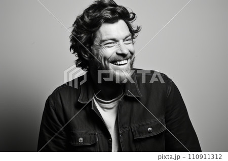 Portrait of a handsome man laughing over grey background. Black and white 110911312