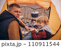 Man and boy tourists autumn time leisure, vacation hiking or traveling touristic activity. Family camping, father and little son relax in forest camp. 110911544