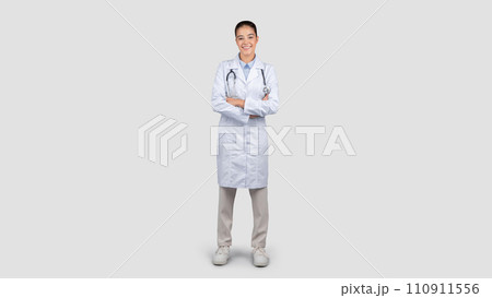 Positive millennial european woman doctor with arms crossed, in white coat 110911556