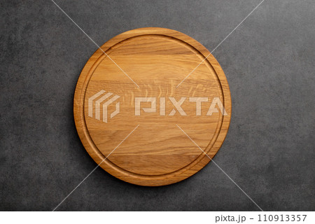 Empty wood round cutting board on black background 110913357