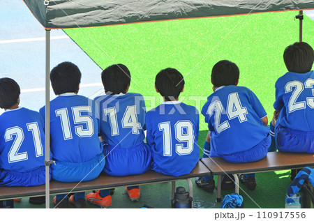 少年サッカーの試合（ベンチで出番を待つ選手達） 110917556