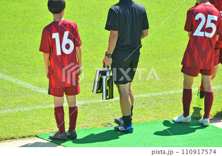 少年サッカーの試合（選手交代準備をする選手と第4審判） 110917574
