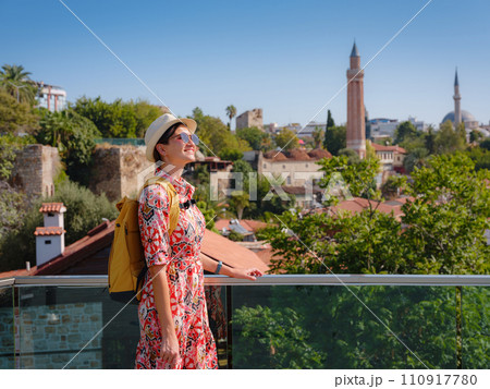 female summer travel to Antalya, Turkey. young asian woman in red dress walk through old town Kalechi , Panoramic view of Antalya Old Town port, Taurus mountains and Mediterrranean Sea, Turkey female summer travel to Antalya, Turkey. young asian woman in red dress walk through old town Kalechi , Panoramic view of Antalya Old Town port, Taurus mountains and Mediterrranean Sea, Turkey 110917780