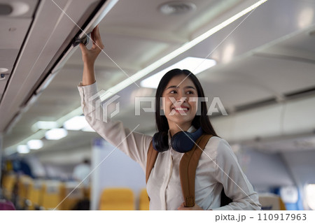 Alone Asian woman passenger traveling by plane. happy traveler on board. Solo travel concept Alone Asian woman passenger traveling by plane. happy traveler on board. Solo travel concept 110917963