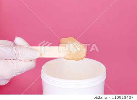Hands cosmetologist holding paste for sugaring depilation. Depilation 110918407