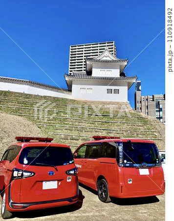 青空に映える岡崎城東隅櫓と二台の消防車(広報車)〈岡崎城公園(多目的広場)/愛知県岡崎市〉 110918492