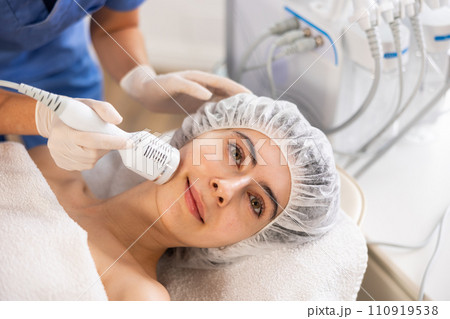 Female patient receiving hardware facial procedure using cooling attachment 110919538