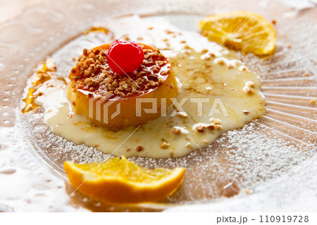 Tocino de cielo with caramel sauce, nuts and orange 110919728