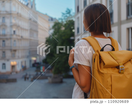 Female tourist traveling in Austria, capital city Vienna. summer female solo trip to Europe, happy young woman walking on european street. 110920689