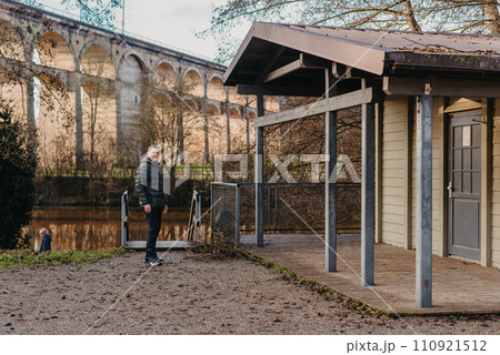 Timeless Elegance: 40-Year-Old Man in Stylish Jacket by Neckar River and Historic Bridge in Bietigheim-Bissingen, Germany 110921512