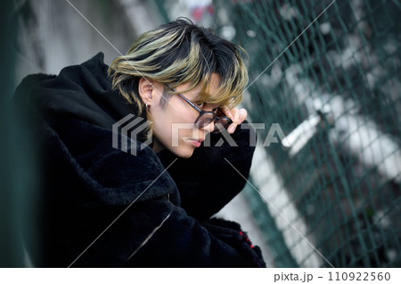 道に座り込むサングラスをかけた若い男性 道に座り込むサングラスをかけた若い男性 110922560