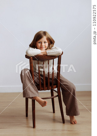 A child in casual clothes jumping on a bed with a pillow in his hands 110922575