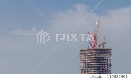 Tower cranes working on the construction site of new skyscraper high-rise building aerial timelapse. Dubai 110922901